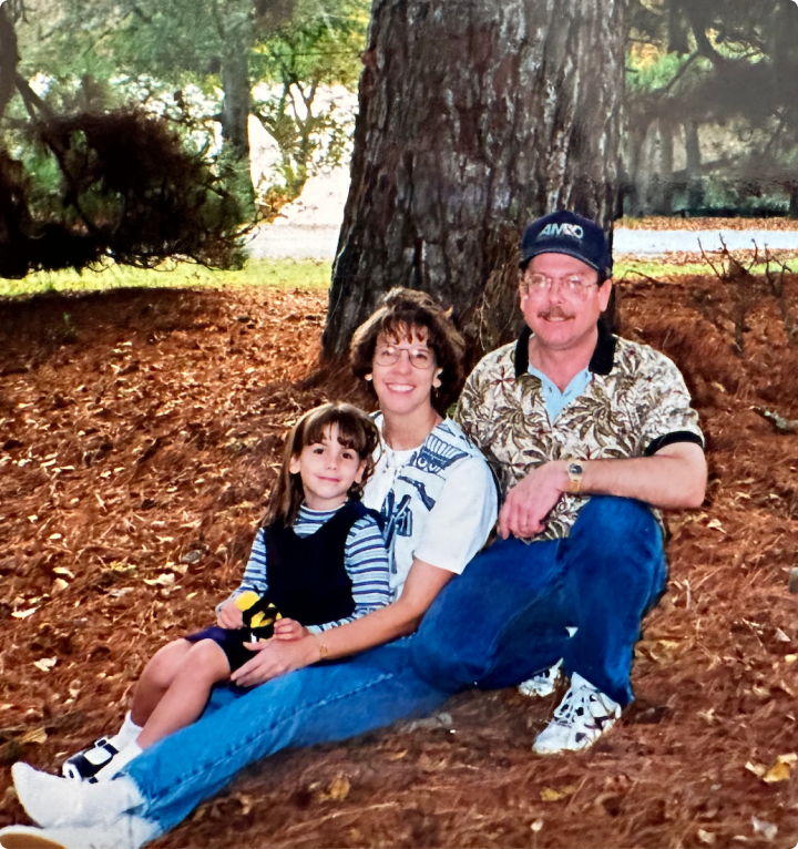 a man and woman sitting in the ground under a tree