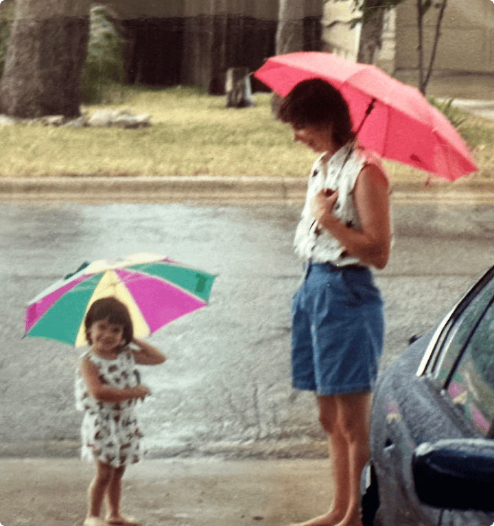 a woman and child holding umbrellas