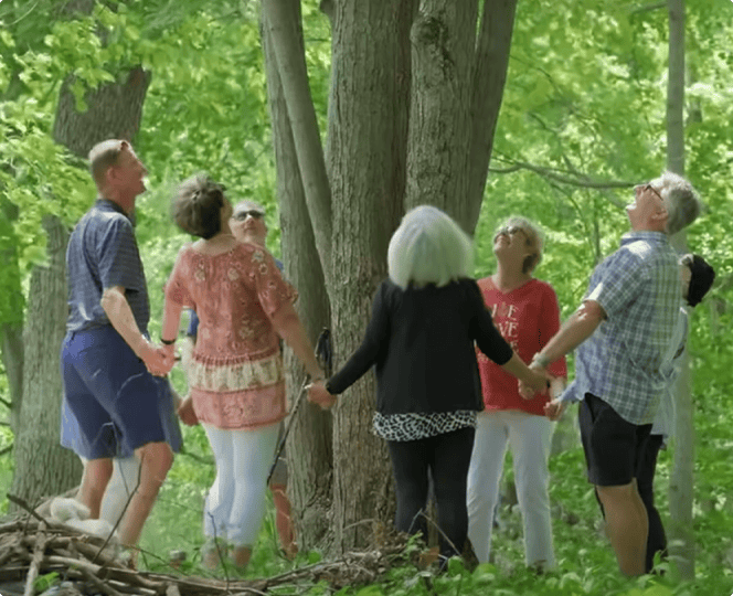 A family reunites in a peaceful Memorial Forest, sharing stories to honor a loved one’s memory.